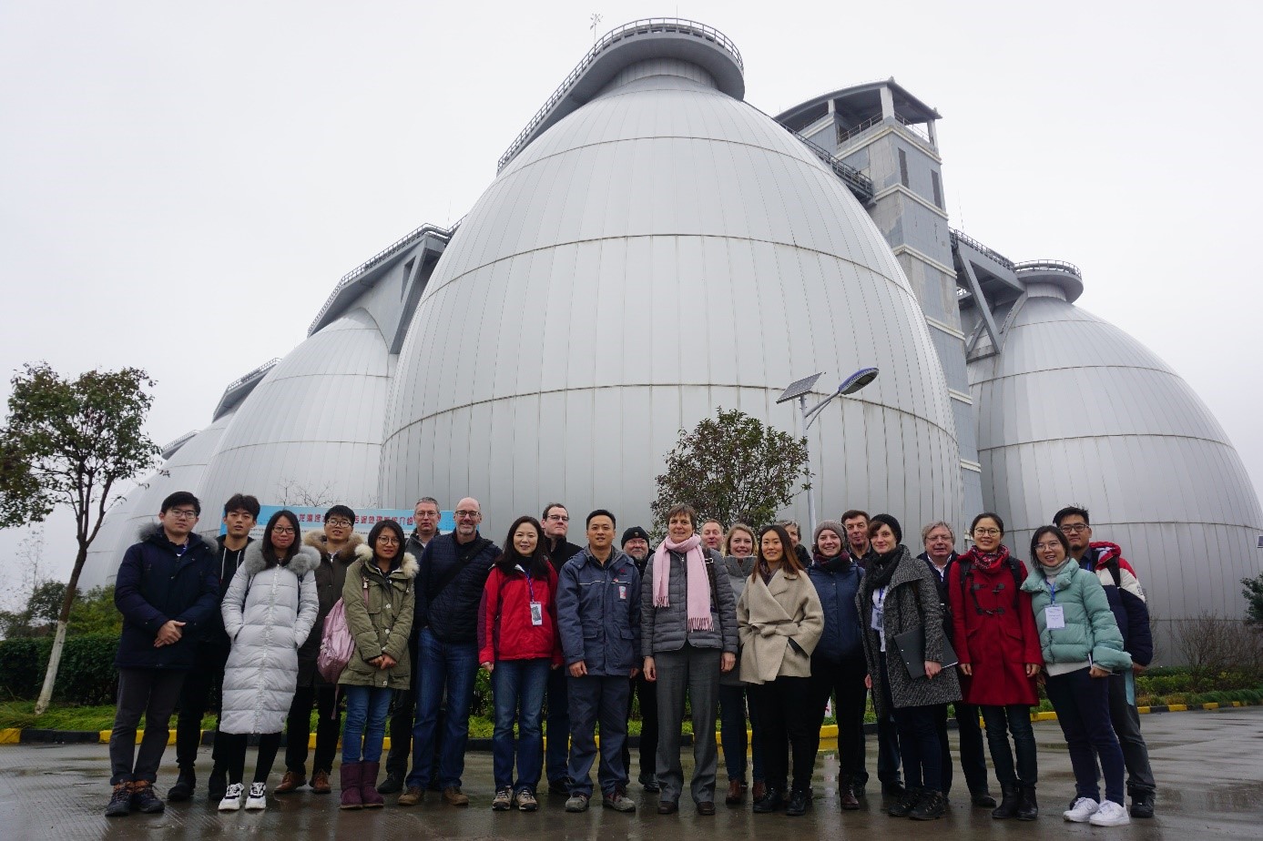 Deutsch-chinesische Besuchergruppe vor den Faultürme einer Kläranlage in Shanghai.